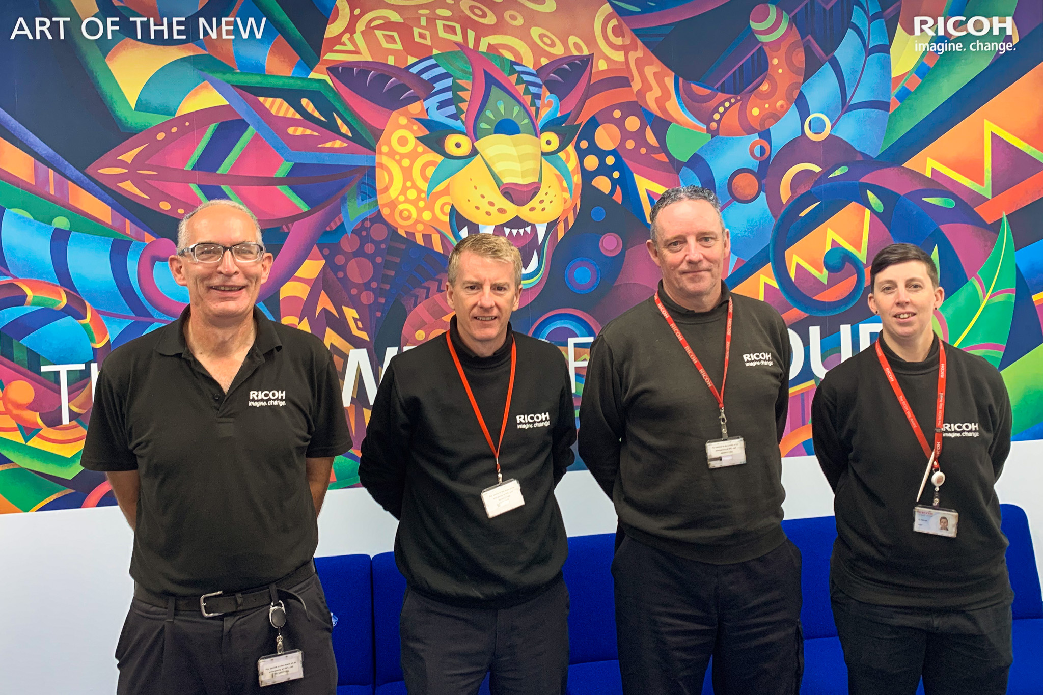 John Hamilton, Derek Smith, Andy McVitie and Sam Davies stood in front of wallpaper made using their Ricoh patented ‘wet-on-wet’ process and RPLS manufactured PO1 Type61010 inks