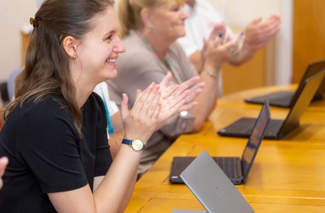 Employees smiling and clapping.